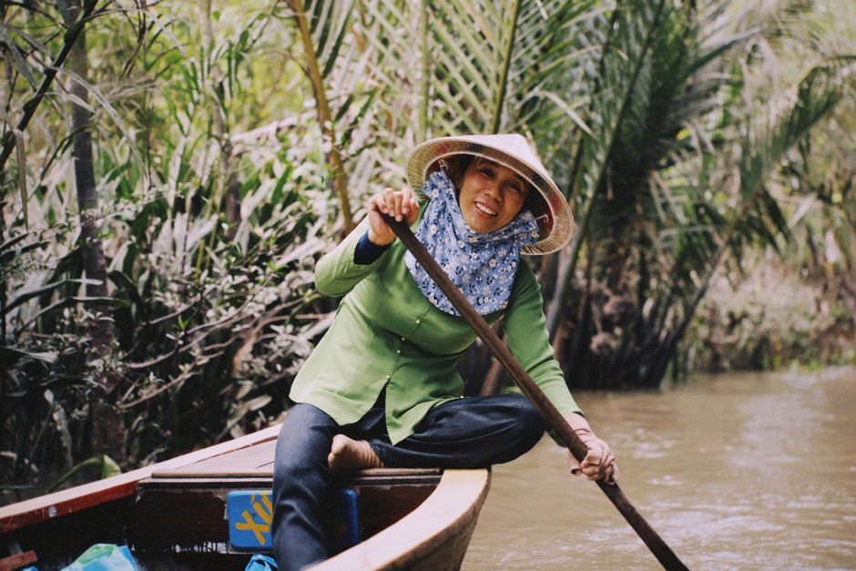 Cặp đôi thư giãn trên thuyền ở Miền Tây sông nước, thưởng thức trái cây